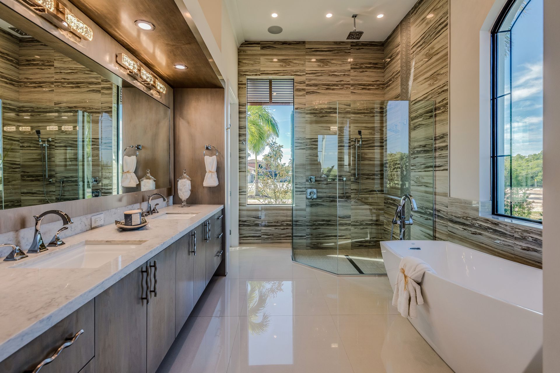 A finished master bathroom with a double vanity, freestanding tub and walk-in shower