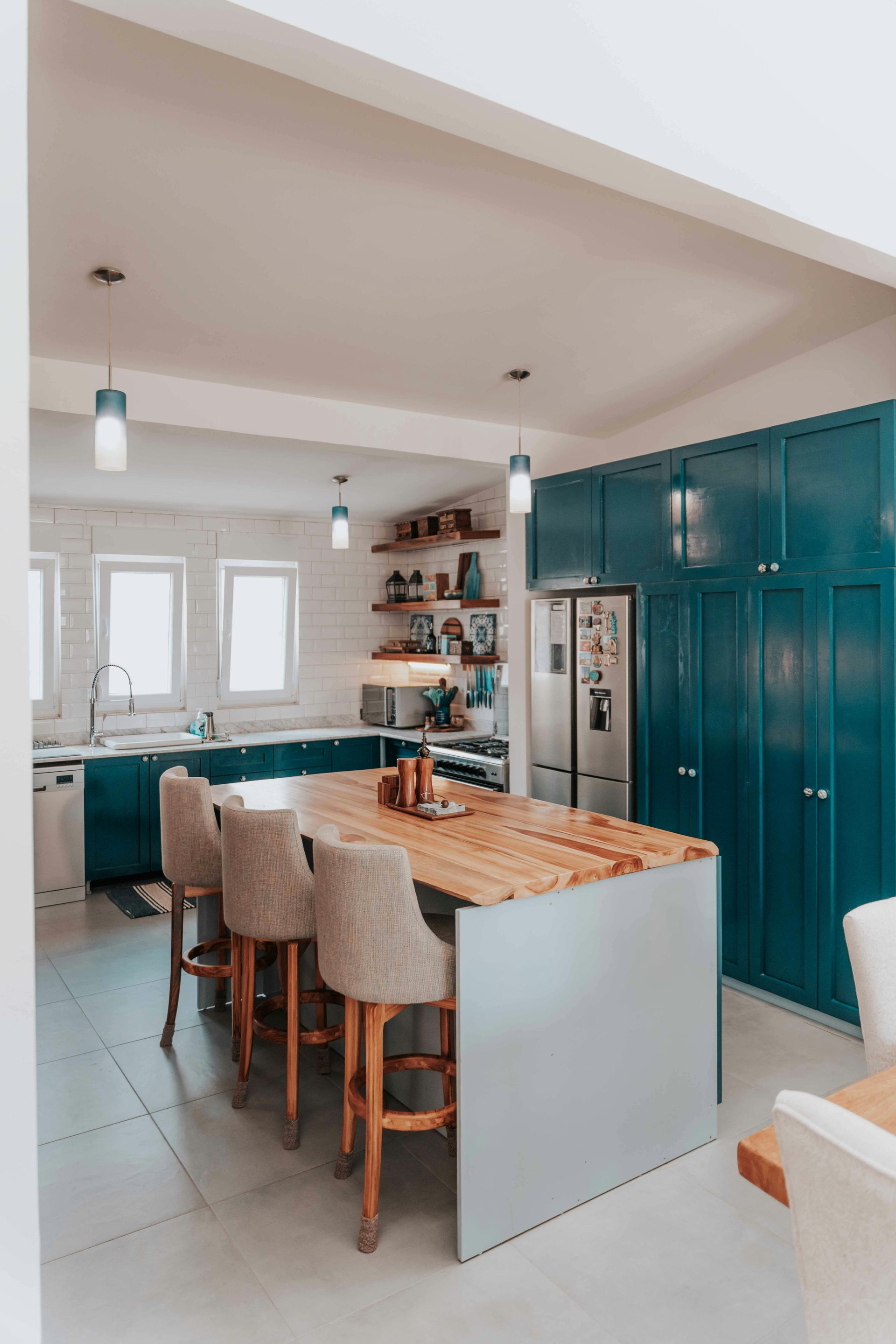 A remodelled kitchen with pale custom cabinetry and a stone island