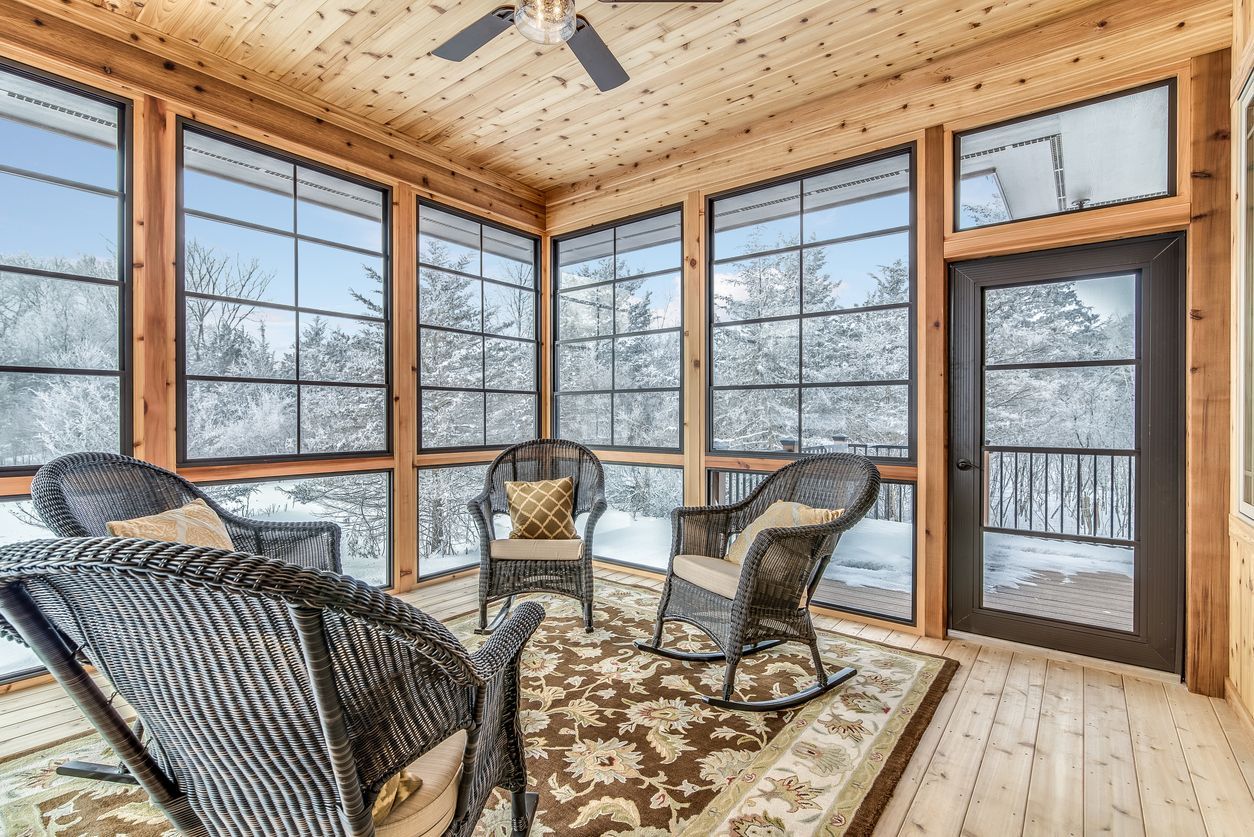 A finished sunroom addition with windows on three sides
